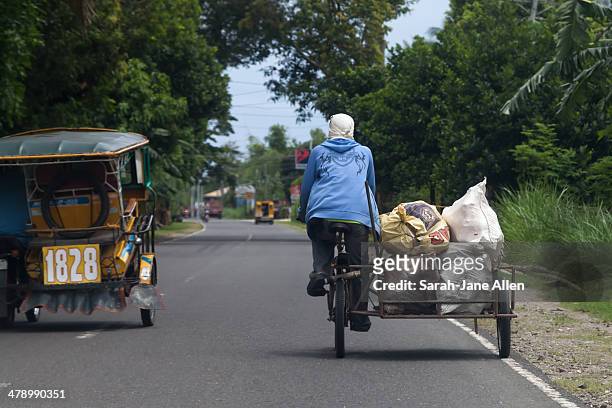 Tricycle and Bicycle cart with bags and the road south of Dumaguete, Negros Oriental, the Philippines
