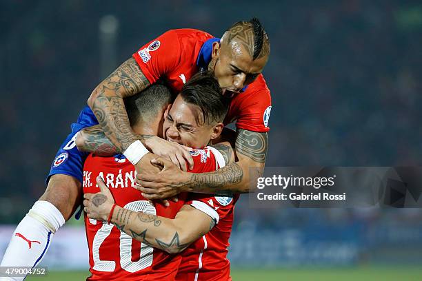 Eduardo Vargas of Chile celebrates with teammates Arturo Vidal and Charles Aranguiz after scoring the opening goal during the 2015 Copa America Chile...