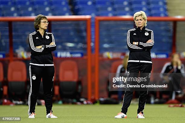 Head coach Silvia Neid of Germany and assistant coach Ulrike Ballweg look on during a training session at Olympic Stadium ahead of their semi final...