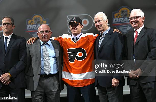 Travis Konecny poses for a group photo onstage with members of the Philadelphia Flyers organization after being selected 24th overall by the...