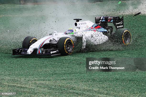 Felipe Massa of Brazil and Williams and Kamui Kobayashi of Japan and Caterham come together and spin out into the gravel at turn one at the start of...