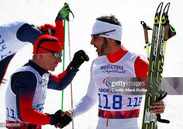 Gold medalist Brian McKeever of Canada is congratulated by Nikolay Polukhin of Russia after crossing the finish line in the Mens Cross Country 10km...