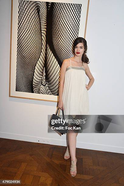 Model Dominique Natalie Isvoranu poses with a work of photographer Daido Moriyama attend the Marisa Schiaparelli Berenson book signing at Christies...