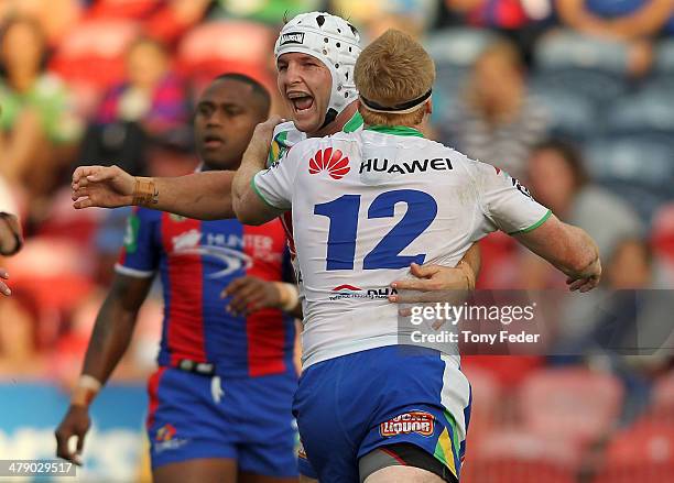 Jarrod Croker of the Raiders celebrates a try with team mate Joel Edwards during the round two NRL match between the Newcastle Knights and the...