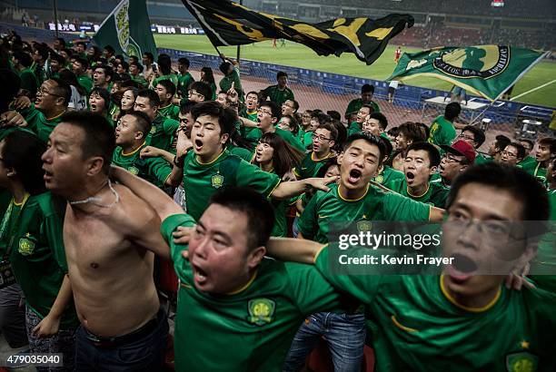 Ultra supporters and fans of the Beijing Guoan FC celebrate together after a goal against Chongcing Lifan FC during their Chinese Super League match...