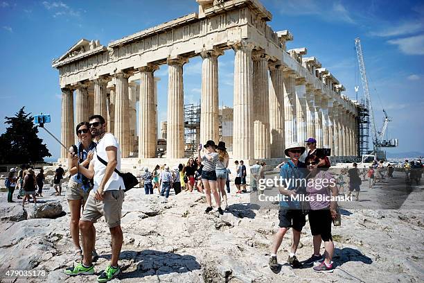 Tourists visit the ancient Acropolis hill, with the ruins of the fifth century BC Parthenon temple on June 30, 2015 in Athens, Greece. Greek voters...