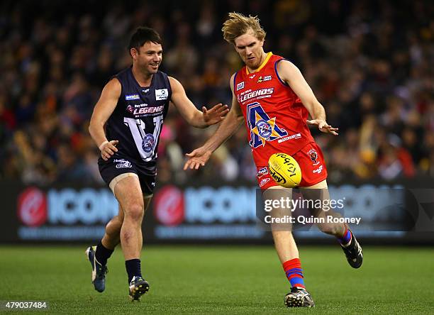 Lewis Roberts-Thomson of the All Stars kicks whilst being tackled by Brent Guerra of Victoria as he kicks during the EJ Whitten Legends Game at...