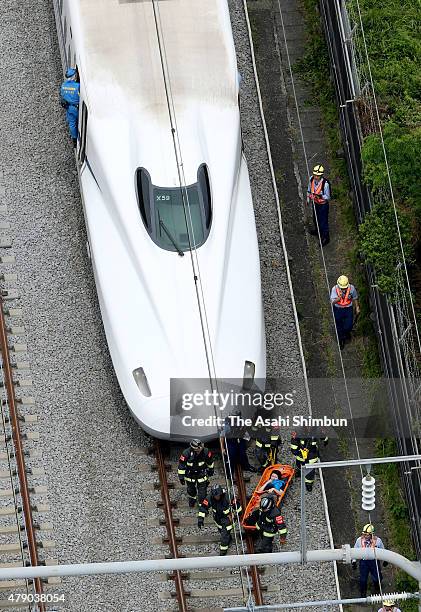 In this aerial image, fire fighters rescue injured passengers on June 30, 2015 in Odawara, Kanagawa, Japan. A man set himself on fire aboard a...