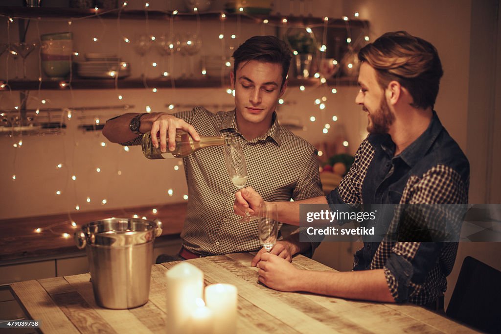Loving gay couple drinking champagne.