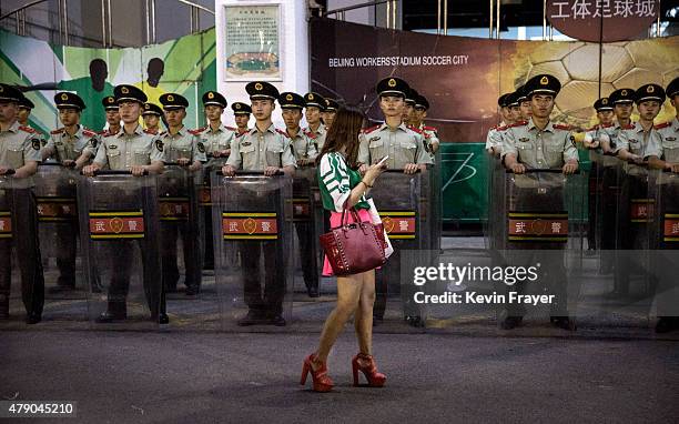 An Ultra supporter of the Beijing Guoan FC walks passed police officers following the team's Chinese Super League match against Tianjin FC on June...