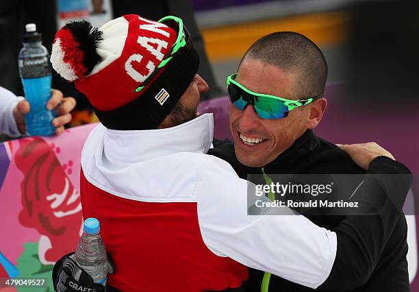 Gold medalist Chris Klebl of Canada is congratulated by teammate Brian McKeever following the Mens Cross Country 10km - Sitting on day nine of the...