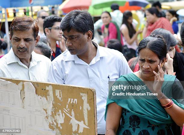 Parents and students check the second cut off list at Maitreyi college for admissions in Delhi University on June 30, 2015 in New Delhi, India. In...