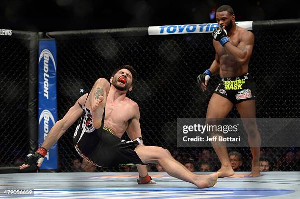 Carlos Condit screams as he falls after being kicked by Tyron Woodley in their welterweight fight during the UFC 171 event inside American Airlines...