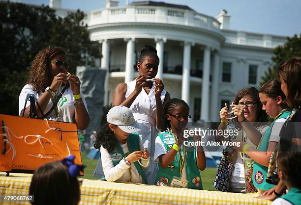 First lady Michelle Obama particiaptes in a knot-tying session with fourth-grade Girl Scouts during the first-ever White House Campout June 30, 2015...