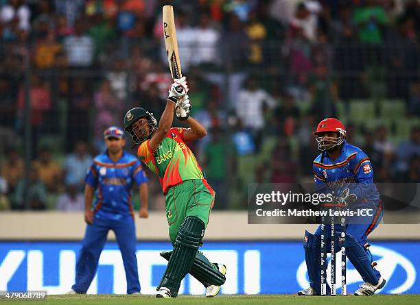 Anamul Haquel of Bangladesh hits the winning runs, as Mohammad Shahzad of Afghanistan looks on during the ICC World Twenty20 Bangladesh 2014 match...