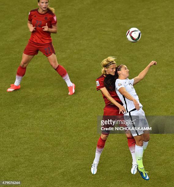 Germany's midfielder Tabea Kemme watches as teammate defender Saskia Bartusiak vies for the ball with USA forward Alex Morgan during the 2015 FIFA...