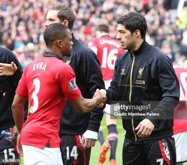 Patrice Evra of Manchester United and Luis Suarez of Liverpool shakes hands ahead of the Barclays Premier League match between Manchester United and...