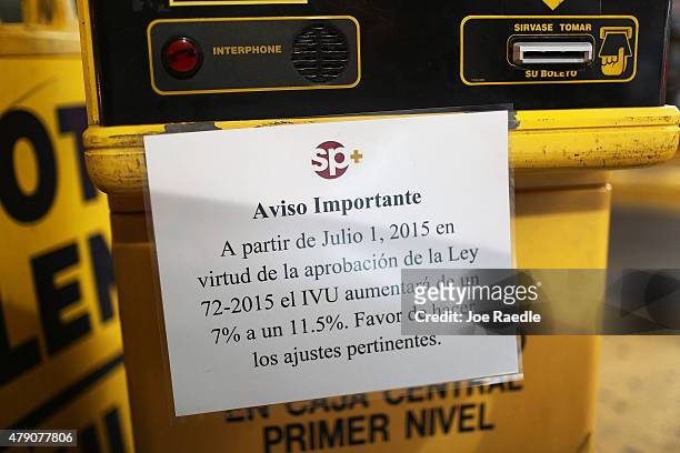 Sign advises customers that after July 1, the tax on parking will rise 11.5 percent from the current 7 percent a day after the Puerto Rican Governor...