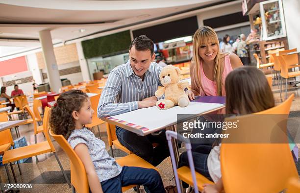happy family having dinner at the shopping center - the 2015 center dinner stockfoto's en -beelden