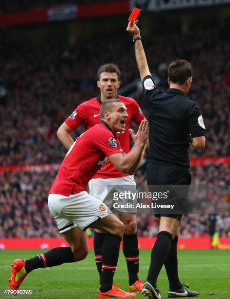 Nemanja Vidic of Manchester United is shown a red card by Referee Mark Clattenburg during the Barclays Premier League match between Manchester United...