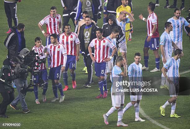 Paraguayan players leave in dejection next to Argentinian player their Copa America semifinal football match in Concepcion, Chile on June 30, 2015....