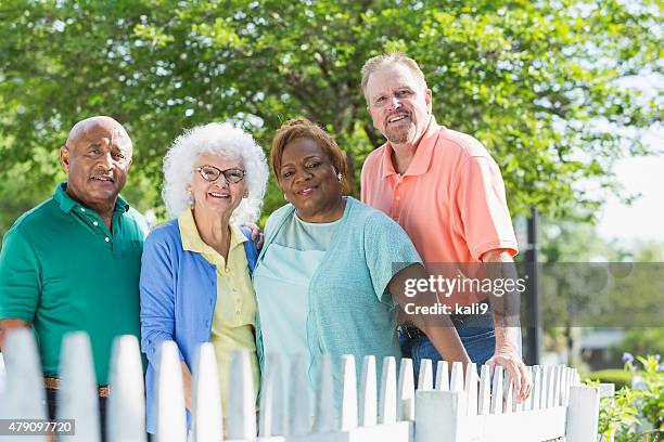 multiracial group of seniors standing outdoors - tuinhek stockfoto's en -beelden
