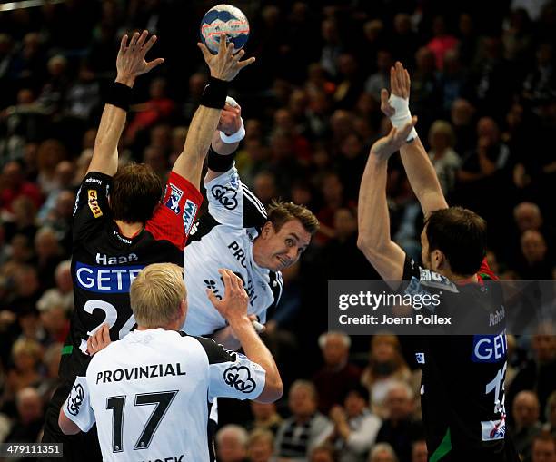 Filip Jicha of Kiel is challenged by Fabian van Olphen and Michael Haass of Magdeburg during the Bundesliga handball match between THW Kiel and SC...