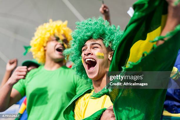 ecstatic brazilian fan watching a football game - international soccer event 個照片及圖片檔