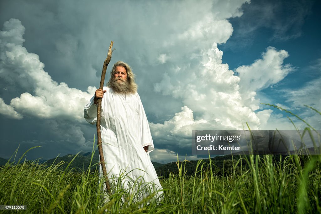 Long-haired prophet standing in front of dramatic sky