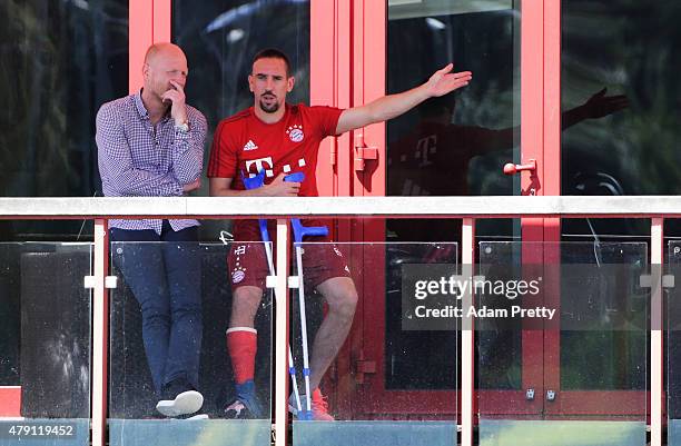 An injured Franck Ribery of FC Bayern Muenchen watches training with FC Bayern Sporting Director Matthias Sammer at the FC Bayern Muenchen training...