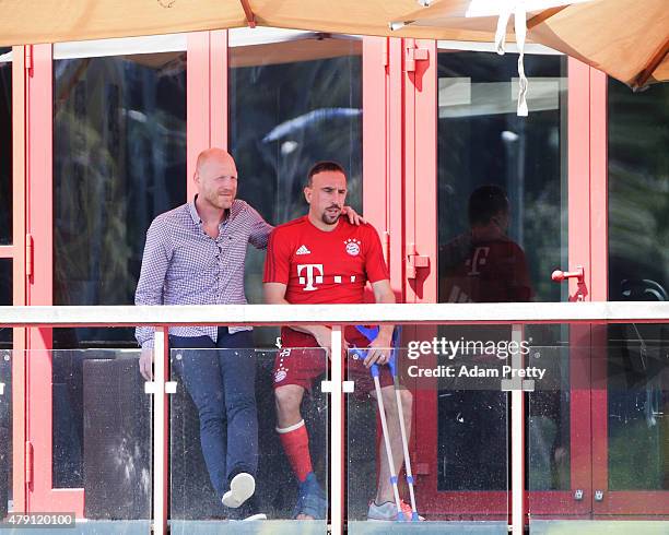 An injured Franck Ribery of FC Bayern Muenchen watches training with FC Bayern Sporting Director Matthias Sammer at the FC Bayern Muenchen training...