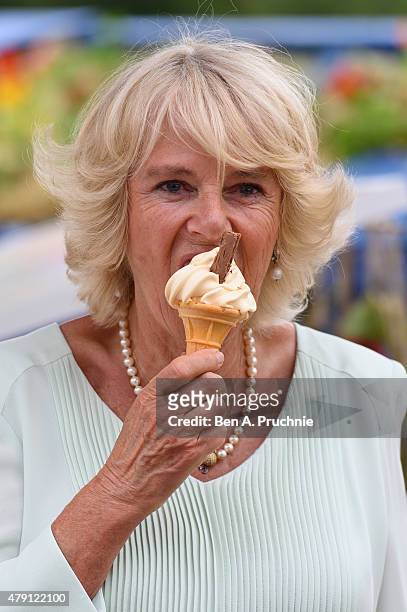 Camilla, Duchess of Cornwall eats an ice cream as she visits the Hampton Court Palace Flower Show at Hampton Court Palace on July 1, 2015 in London,...