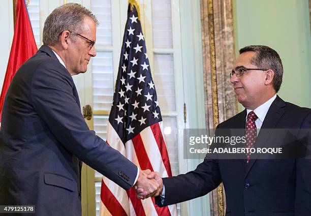 The head of US Interest Section, Jeffrey DeLaurentis , shakes hands with Cuban Foreign Vice-Minister Marcelino Medina after giving him a letter from...