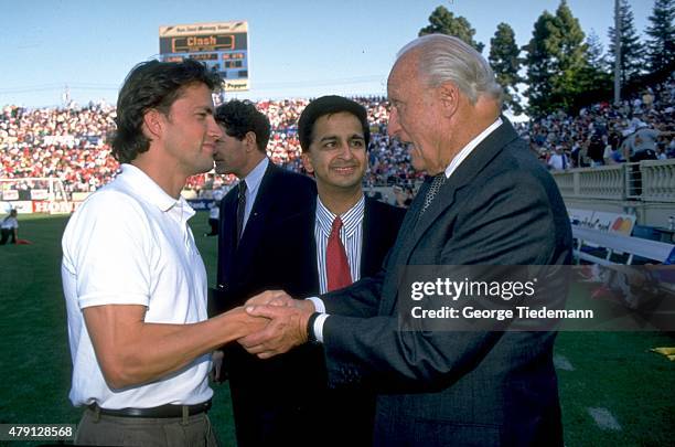 President Joao Havelange shaking hands with Los Angeles Galaxy player Andrew Shue on sidelines with MLS deputy commissioner Sunil Gulati looking on...