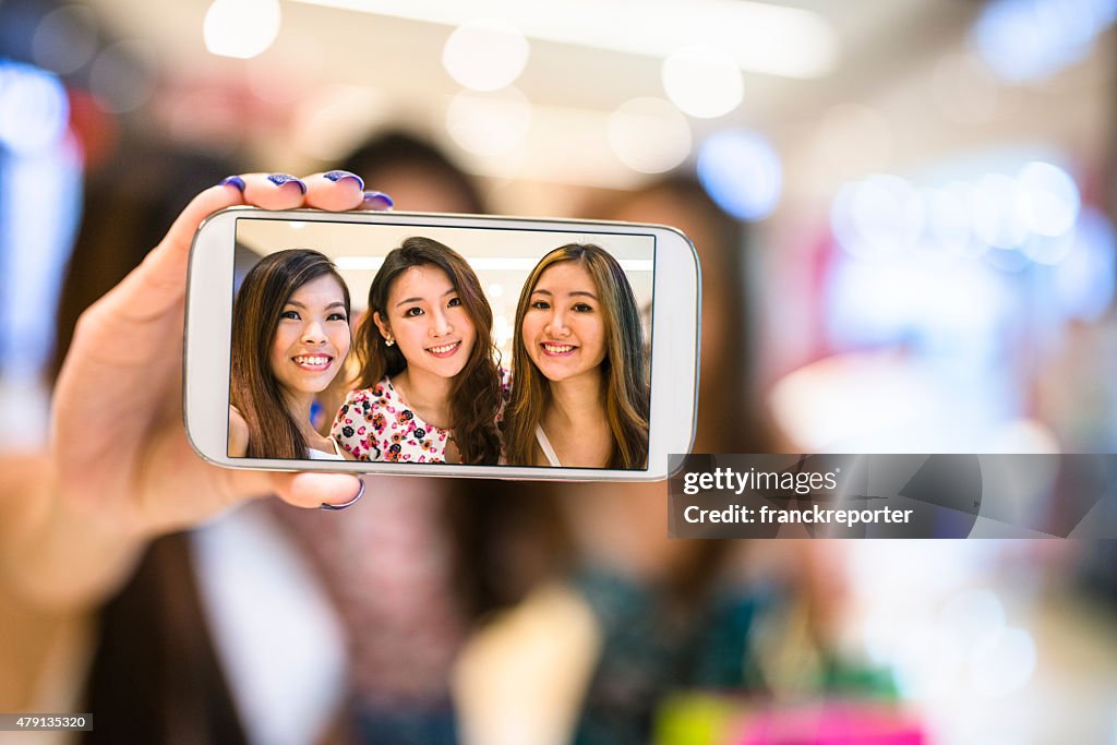 Asian friends shopping in the mall and take a selfie