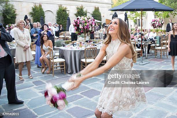 Courtney Sixx tosses her bouquet at her wedding to Nikki Sixx at Greystone Mansion on March 15, 2014 in Beverly Hills, California.