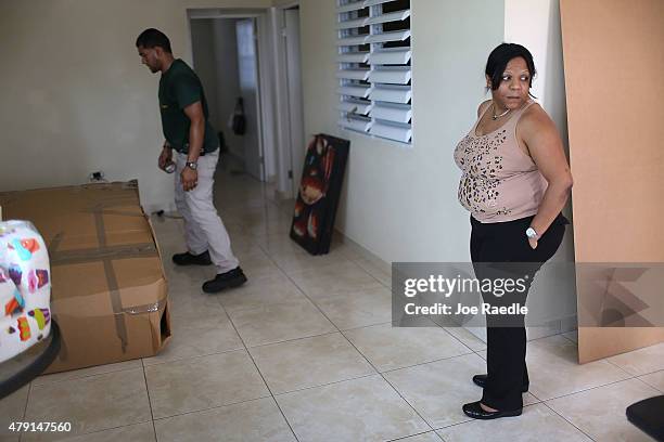 Yessenia Puente watches as movers from La Rosa del Monte moving company pack up her apartment as she prepares to move to Orlando, Florida this...