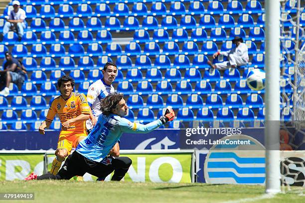 Damian Alvarez of Tigres scores the goal of his team as Jorge Villalpando of Puebla falis to block during a match between Puebla and Tigres UANL as...