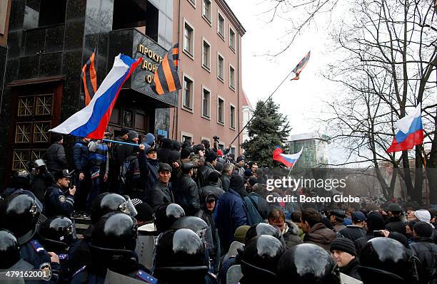 Pro-Russian protesters stand on the steps of the Donetsk Prosecutors Building after overtaking riot police and storming into the building during a...