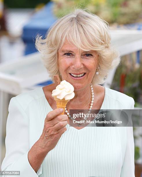 Camilla, Duchess of Cornwall eats an ice cream as she attends The Hampton Court Flower Show at Hampton Court Palace on July 1, 2015 in London,...