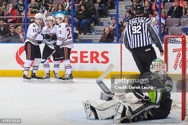 Evan Polei, Rhyse Dieno, and Wyatt Johnson of the Red Deer Rebels celebrate the goal of Dieno against Tyler Santos of the Edmonton Oil Kings during a...