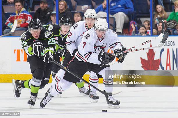 Lane Bauer of the Edmonton Oil Kings tries to check Brady Gaudet of the Red Deer Rebels during a WHL game at Rexall Place on March 16, 2014 in...