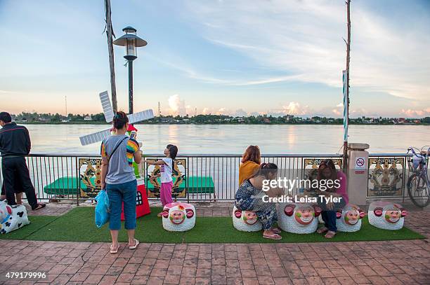 Locals relax on sheep statues at a night market set up long the Mekong River in the Issarn town of Nong Khai.