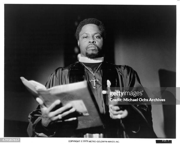 Actor Roger E. Mosley stands with bible in a scene from the MGM movie "Sweet Jesus, Preacherman" circa 1973.