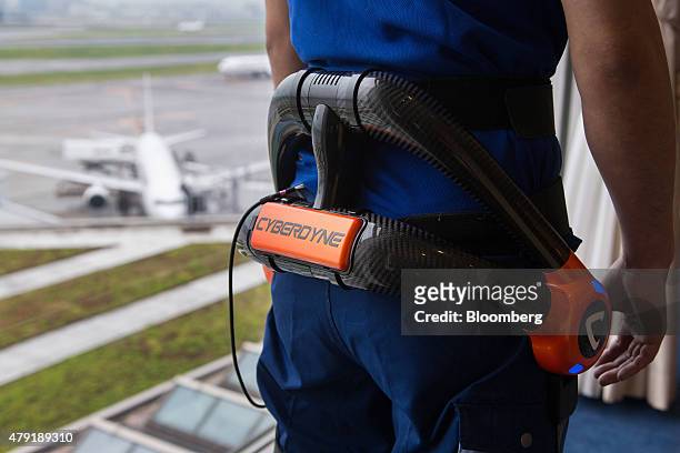 Japan Airport Terminal Inc. Employee poses for a photograph while wearing the Hybrid Assistive Limb exoskeleton robot suit developed by Cyberdyne...