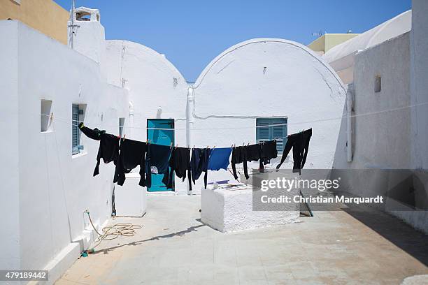 Washing line with laundry in a yard is pictured on a sunny day in the town of Oia on June 11, 2015 in Santorini, Greece. Santorini is an island in...