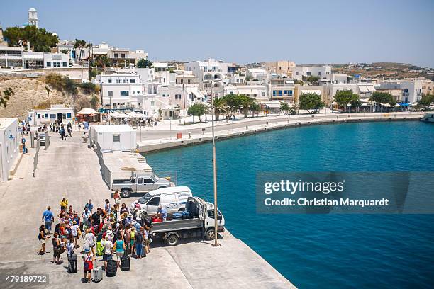 Tourist gather in a group at a port after leaving a ferry on the way to Sifnos island on June 16, 2015 in Sifnos, Greece. Sifnos is a island in the...