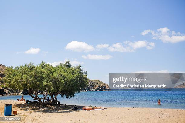 Tourist relax on the beach during midday next to the town of Faro on June 19, 2015 in Sifnos, Greece. Sifnos is a island in the western Aegean Sea,...