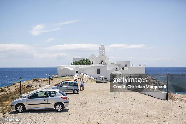 Cars stand at a parking yard in front of the abby of 'Panagia Chrissopigi' during midday in the town of Faro on June 19, 2015 in Sifnos, Greece....