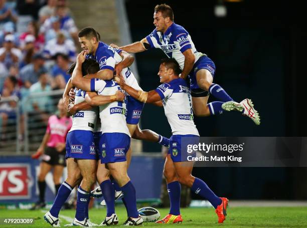 Bulldogs players celebrate the try to Michael Ennis as Josh Reynolds jumps over the top during the round two NRL match between the...